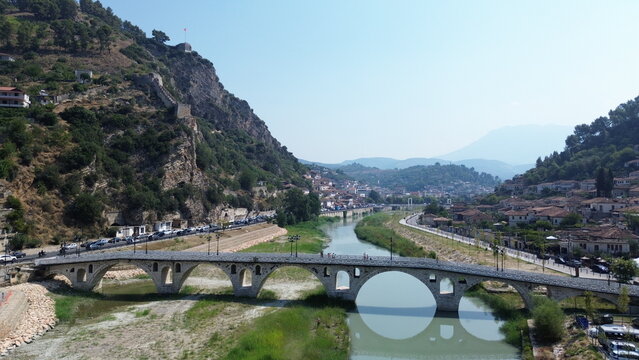 Cinematic aerial view of the iconic UNESCO stone town of Berat and the historic Gorica bridge over Osum river, Albania