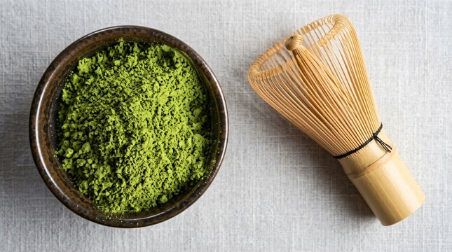 Matcha Green Tea Powder with Bamboo Whisk in Bowl on Light Textured Surface