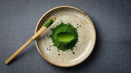 Fototapeta premium Green Matcha Powder in Ceramic Plate with Bamboo Scoop on Gray Surface