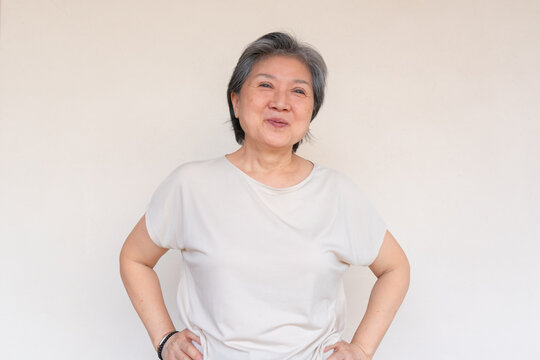 Cheerful Senior Asian Woman with Grey Hair Smiling Genuinely and Confidently at the Camera
