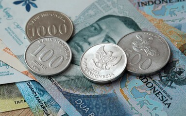 Indonesian rupiah money bills and coins on table. Indonesia cash of IDR currency © Larysa