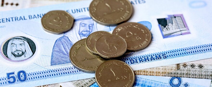UAE dirham money bills and coins on table. United Arab Emirates cash of AED currency close up