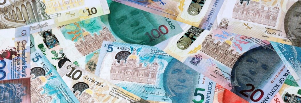 Scottish pound money banknotes bunch on table. Scotland bills of GBP currency close up