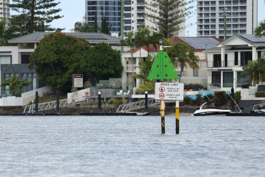 Waterway Speed Limit Sign with Waterfront Homes and High-Rise Buildings