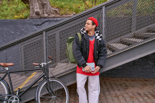 Stylish young man enjoying city life as he heads to class with confidence