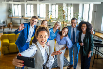 Obraz premium Diverse business team taking group selfie in office