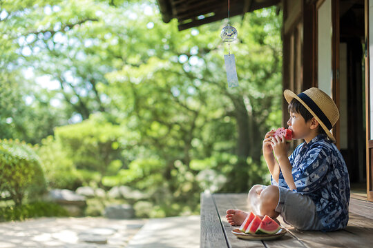 A boy eating watermelon on the Engawa