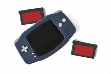Top view flat lay of a classic dark blue portable handheld video game console with cartridge on PNG Di-Cut background. Retro equipment. © punpolpoke