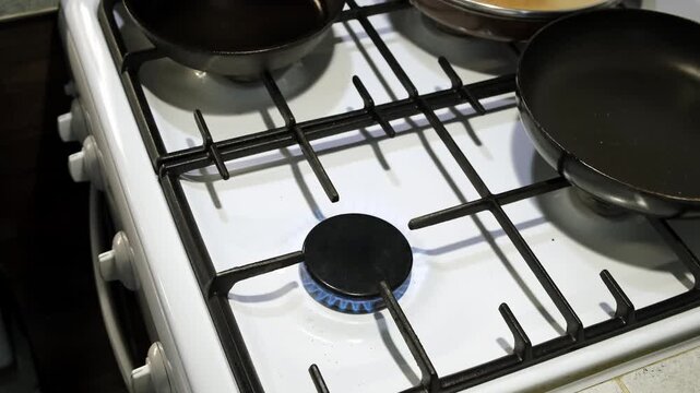 A neutral gas stove with metallic grates is showcased in a modern kitchen setting viewed from a top-down perspective. The scene features a clean and bright environment with a white and dark.