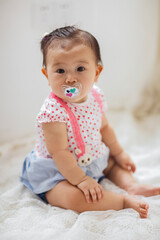 Fototapeta premium A cute 1-year-old Asian girl indoors