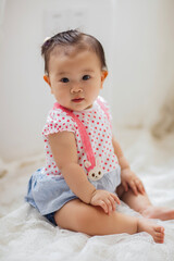 Fototapeta premium A cute 1-year-old Asian girl indoors