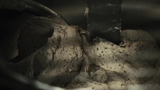 Industrial dough mixer with spiral blade completes dough kneading process after intensive dough mixing. Close up view of final preparation for bakery food. Small business bread production