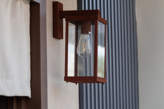 Close-up of a traditional lantern fixture on a modern home exterior wall