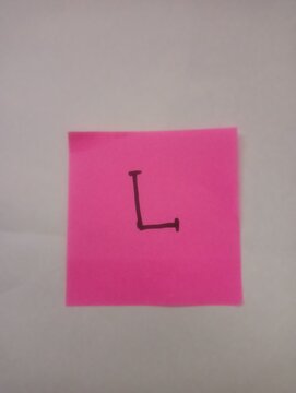 A single letter L in capital font, hand-drawn with black marker on square pink sticky note paper isolated on white background.