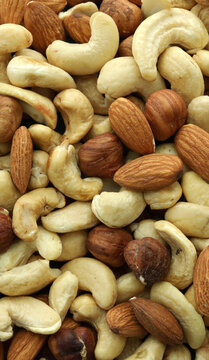 Detailed view on almond and cashew nuts in big pile on table close up