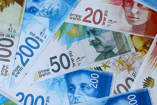 Israeli new shekel money bills in pile on table. Israel ILS currency cash close up