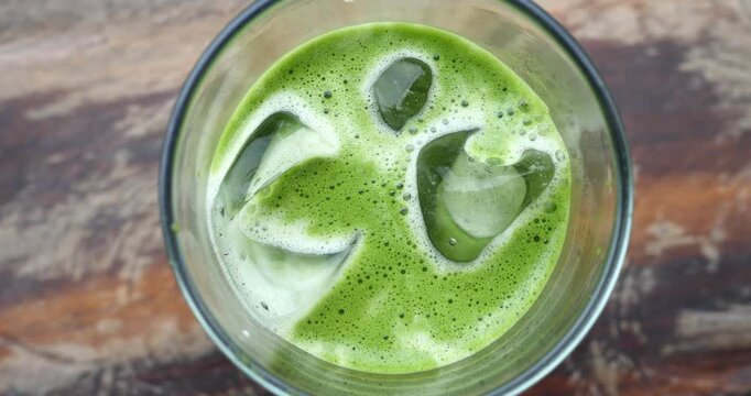 Matcha Iced Drink: A vibrant green matcha drink is served cold with ice cubes in a clear glass, creating a refreshing and invigorating beverage.