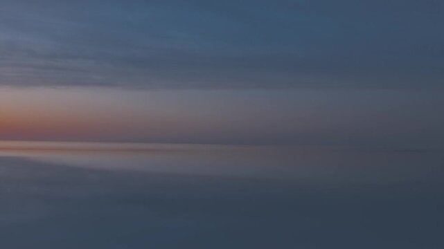 Calm ocean water at dusk with subtle sunset sky reflection, 3D animation