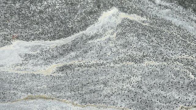 Natural foamy, marble-like patterns move slowly on the water's surface; an abstract natural background.