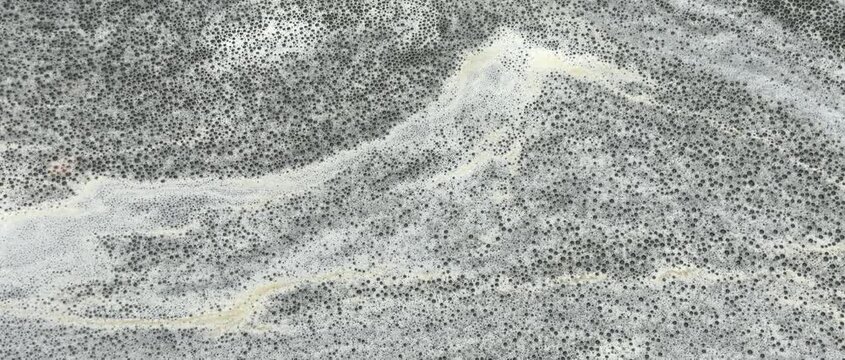 Natural foamy, marble-like patterns move slowly on the water's surface; an abstract natural background.
