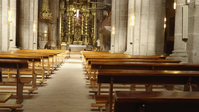 A forward dolly shot moves down the central aisle of a grand gothic cathedral toward the altar.