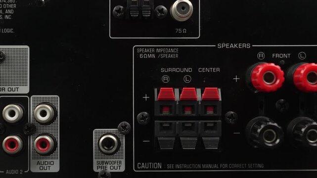 Tight shot of an AV receiver back panel showing surround speaker terminals and clustered analog o outputs.