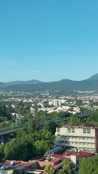 Vertical panoramic view of southern Mexico City at summer sunrise, featuring the Ajusco mountain range surrounding the Mexican capital with warm morning light.