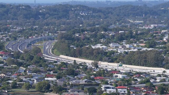 Slow reverse aerial view panning left over the M1 Motorway near Palm Beach and Tallebudgera Creek on the Gold Coast, Queensland, Australia