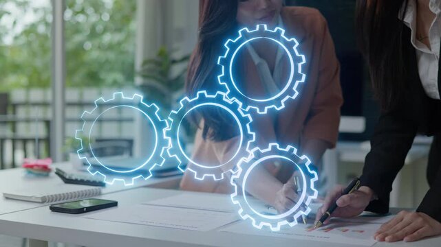 Business team reviewing reports with virtual gears overlay, representing workflow automation, process improvement, collaboration and business strategy.