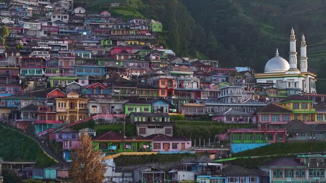 Drone view of Stunning mountain village panorama with lush vegetation and traditional countryside homes. Quiet rural atmosphere with scenic hillside scenery. Nepal Van Java, Indonesia.