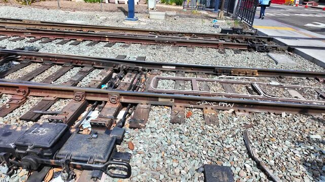 Detailed view of a railway switch with turnout, point machine, and sleepers on gravel ballast