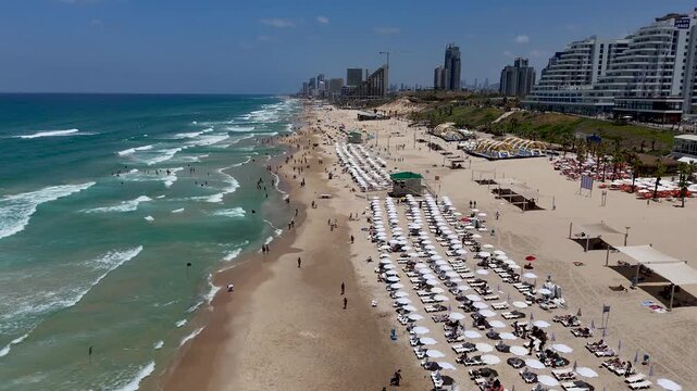 rishon lezion, israel, gush dan, tel aviv skyline, beach, drone pullback, aerial tracking shot, 4k resolution, normal speed, real time footage, mediterranean sea, looking north, crowded beach, summer