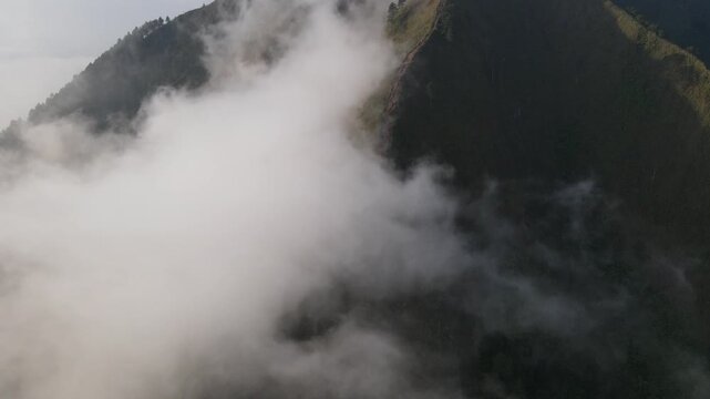 Cinematic opening footage. Mist shrouds Mount Andong, Central Java, Indonesia.