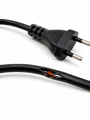 Fototapeta premium Vertical photo of a damaged black electrical power cable with exposed copper wires. Broken and frayed cord with a two-pin plug on a white background. Safety hazard and short circuit risk concept