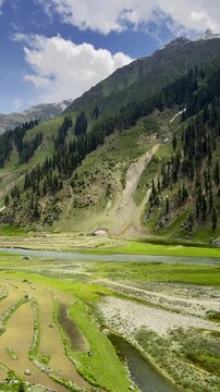 Kunhar River Flowing Through Green Valley with Terraced Fields Rural Landscape and Mountain Village Near Naran Kaghan Pakistan
