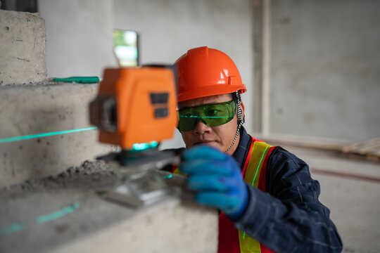 Construction professional utilizing a laser level to ensure accurate measurements on a job site