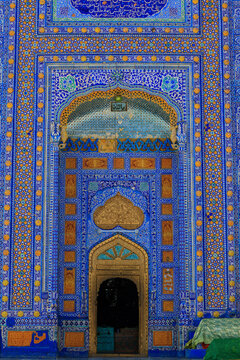 View of the ornate blue and gold tiled entrance of the Shrine of Sachal Sarmast with intricate geometric patterns and calligraphy in Daraza Sharif, Sindh, Pakistan.