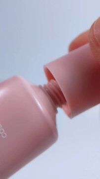 Opening a pink cosmetic packaging, perfect for beauty blogs, skincare routines, and health concepts.