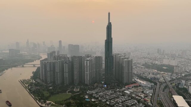 Aerial view at Landmark 81 - it is a super tall skyscraper and Saigon bridge with development buildings along Saigon river, cityscape in the Sunset