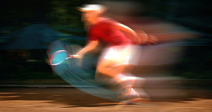 Tennis player sprinting across court with motion blur during fast paced rally. Concept of tennis tournaments, sports equipment advertising, athletic training, competition promotion, active lifestyle.