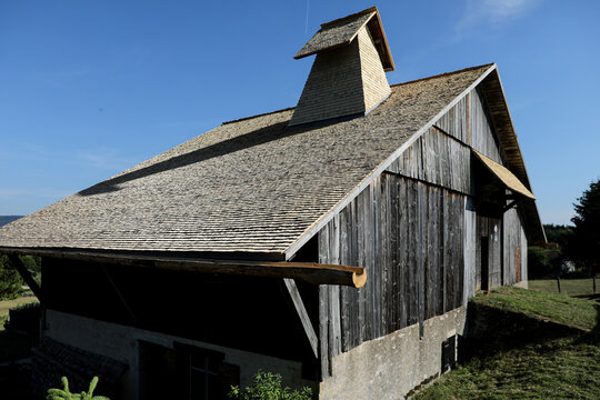 Historic wooden farm building with tavaillon roof in the French Jura