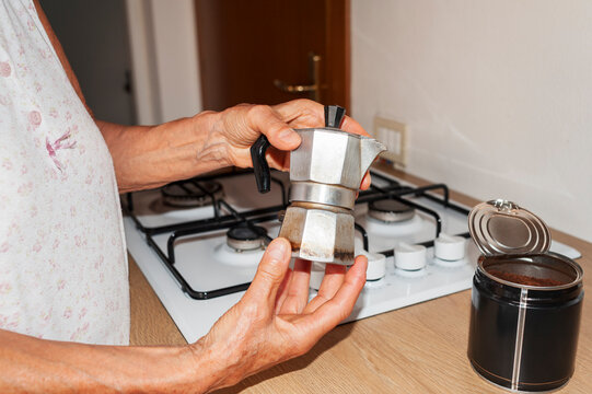Holding Stovetop Moka Pot Beside Ground Coffee Container