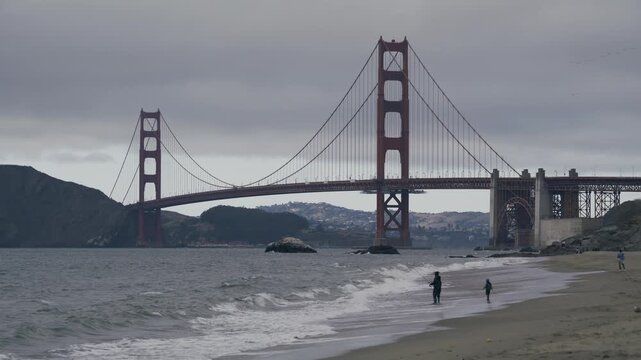 Silhouettes Of People Fishing At Beach Near Golden Gate Bridge With Overcast Sky - Wide Shot
