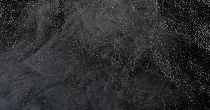 Dark texture with smooth haze. High-resolution dark textured background with gentle flowing haze and particles in smooth motion. Ideal for moody and cinematic backgrounds.