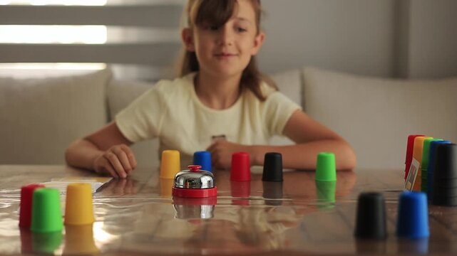 Young girl playing an educational card game at home