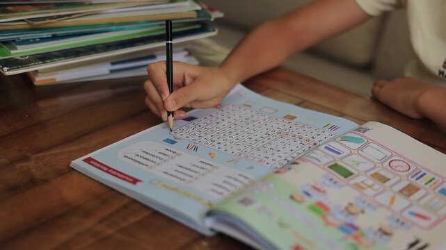 Young girl studying at home with a stack of books