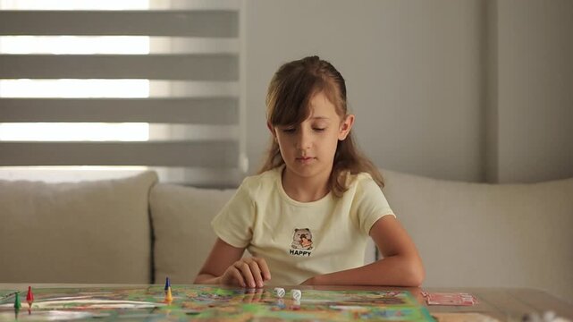 Young girl playing an educational card game at home