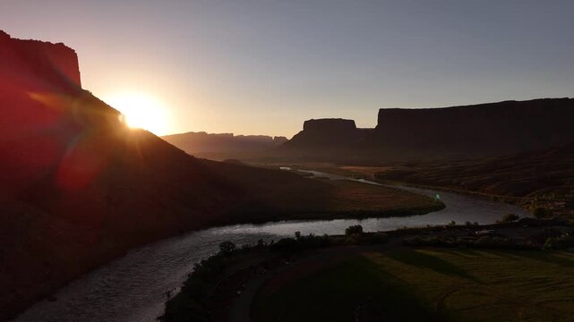 Drone flying sideways exposing the sunrise at the Colorado river in Moab in 4k