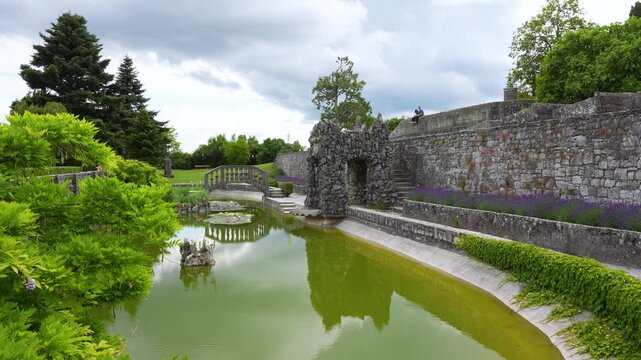 Ferrari Garden at &Scaron;tanjel Castle in Slovenia&rsquo;s Karst region, featuring historic stone architecture, landscaped grounds, ornamental pond and tranquil reflections