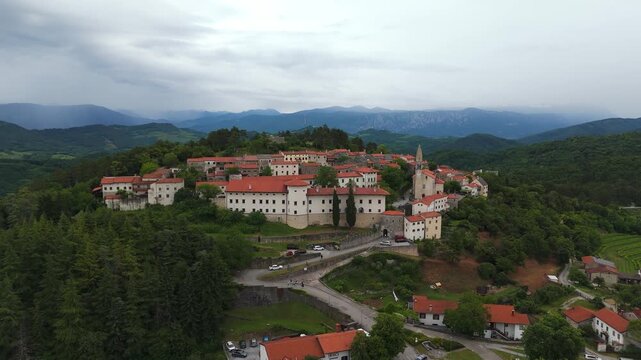 Aerial: historic Stanjel Castle on the Karst Plateau overlooking the Vipava Valley during the day in Stanjel, Slovenia, jib up drone shot